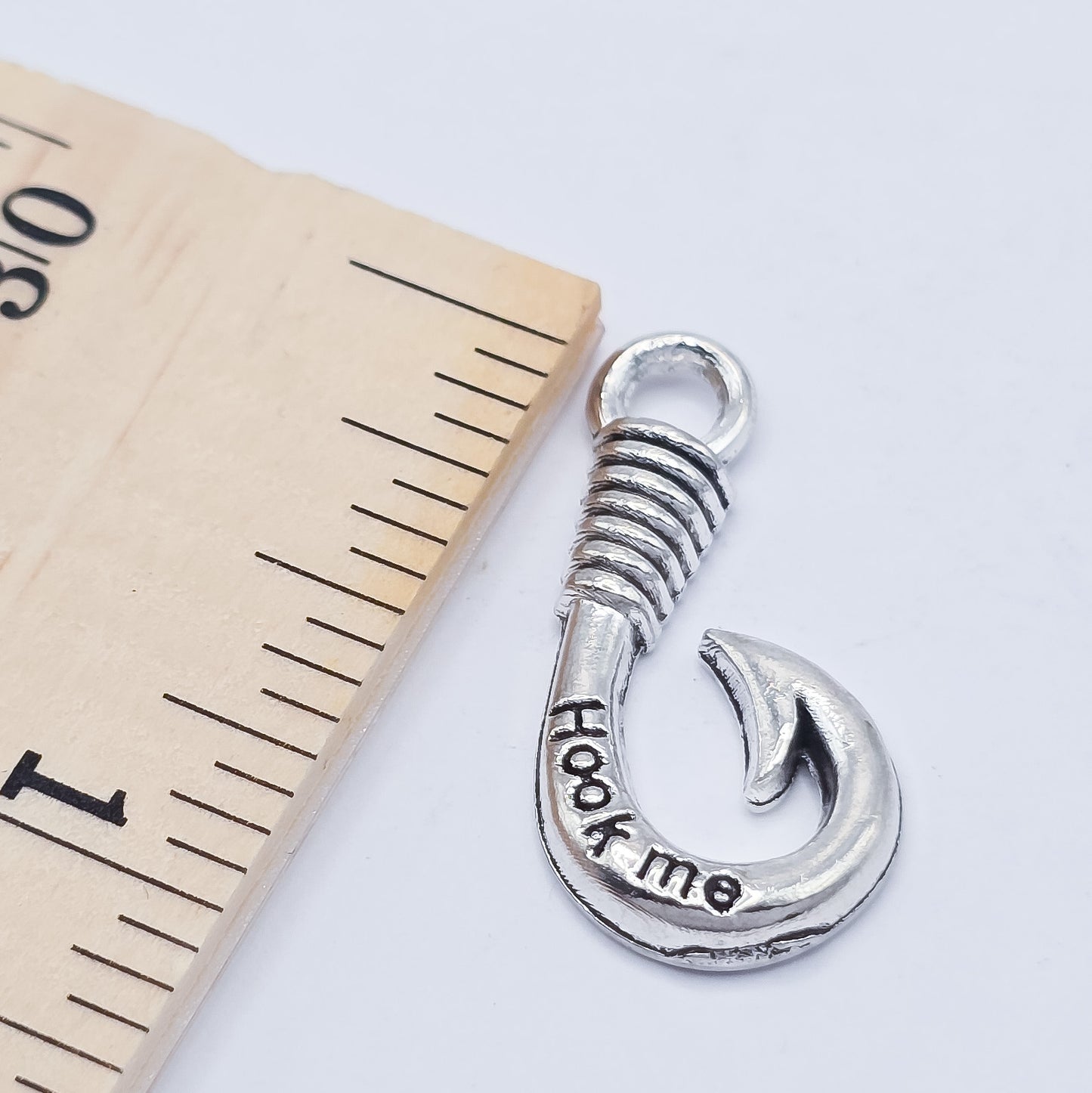 silver fishing hook charm with "hook me" imprinted