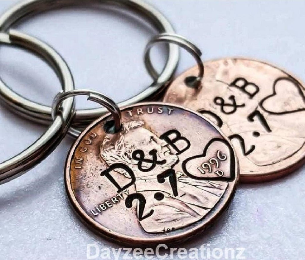 2 penny keychains with couples initials and anniversary date stamped, heart stamped around the penny year